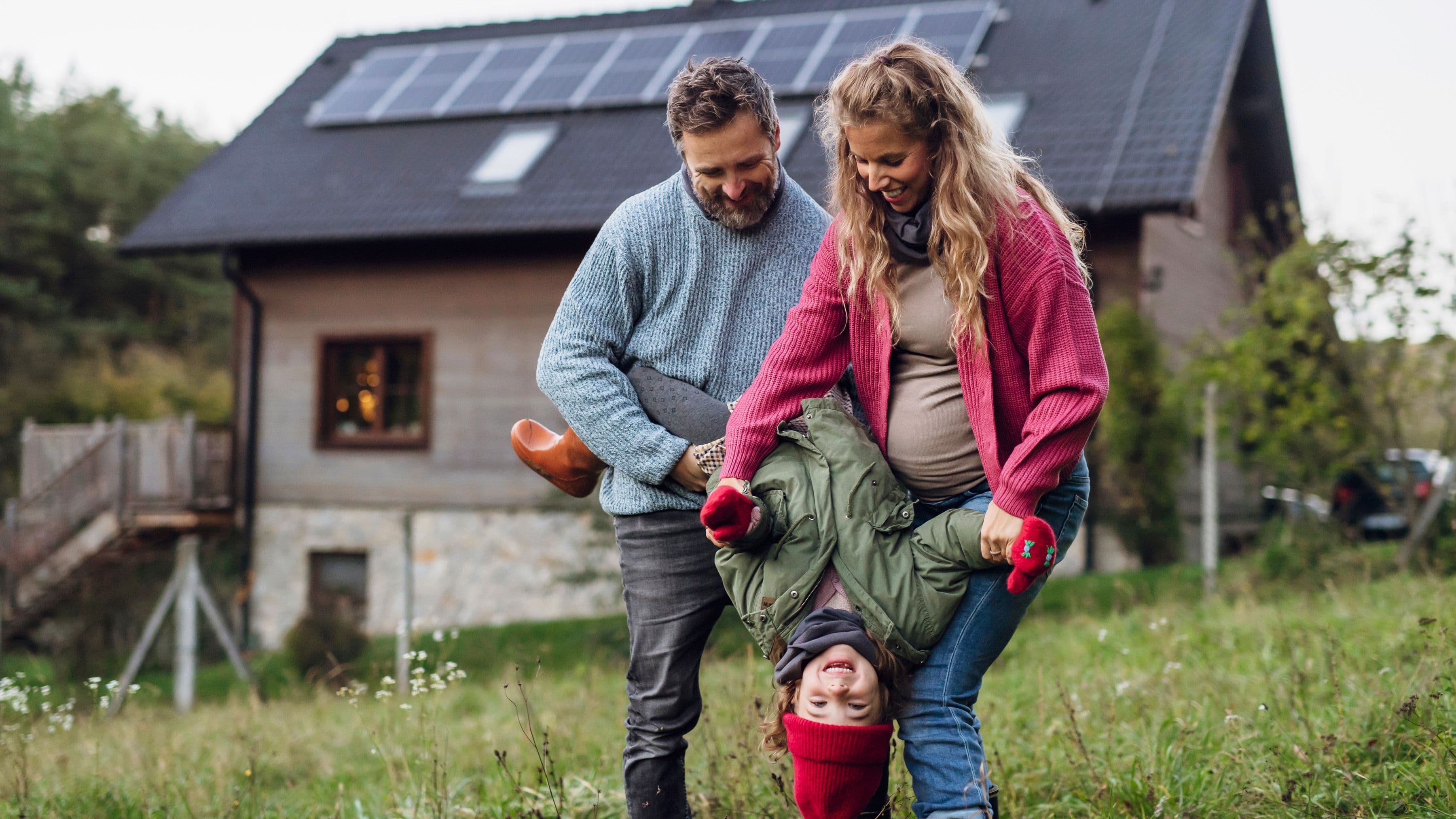 familj framför hus med solpanel