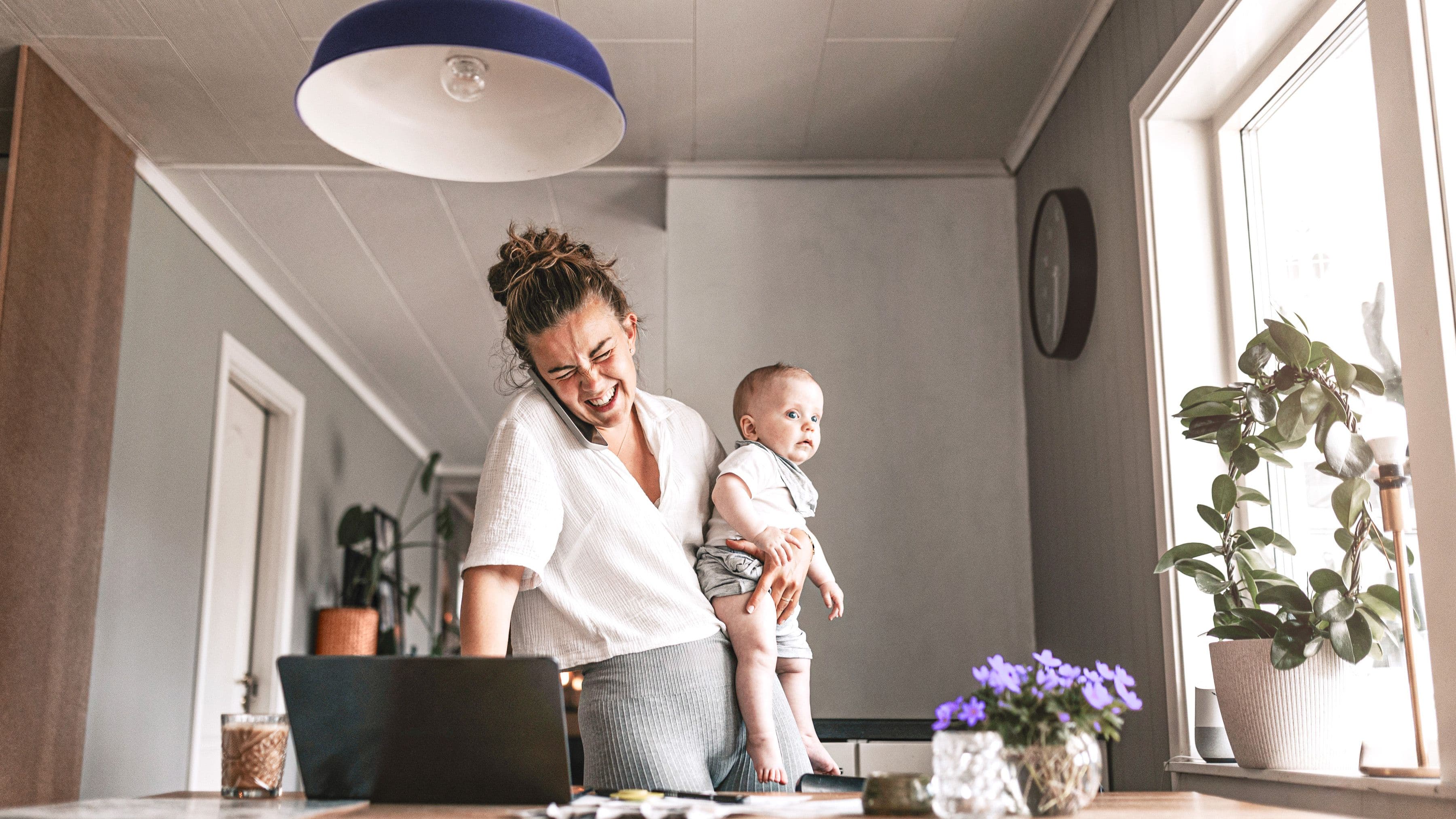 Jobbande mamma håller sin baby