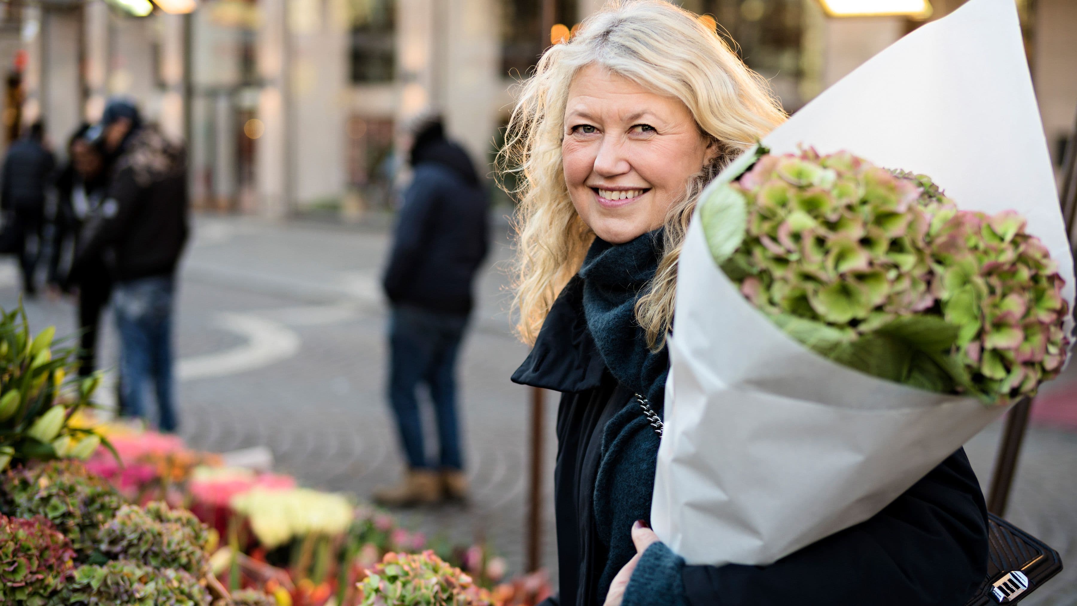 kvinna som handlar blommor på torget