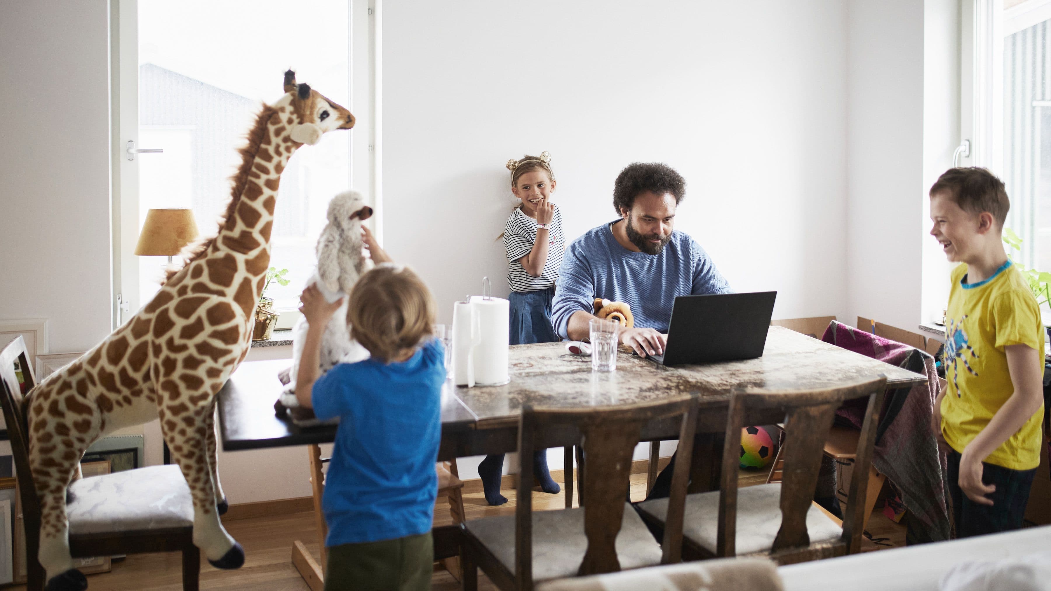 pappa jobbar när barn leker med giraff